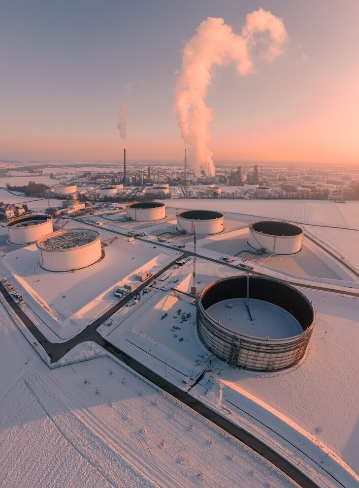 Industrial tanks in a snowy landscape at sunrise